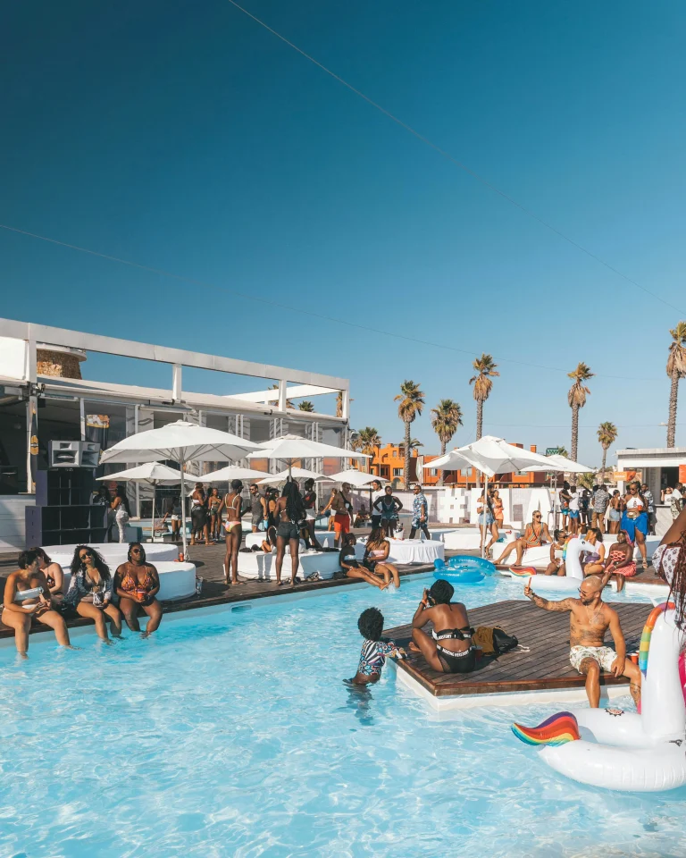 Pool party en plein air avec piscine, espace de détente et participants réunis dans une ambiance festive.