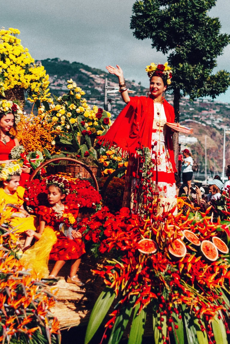 Défilé fleuri à Madère avec costumes traditionnels, compositions florales colorées et participants à la fête