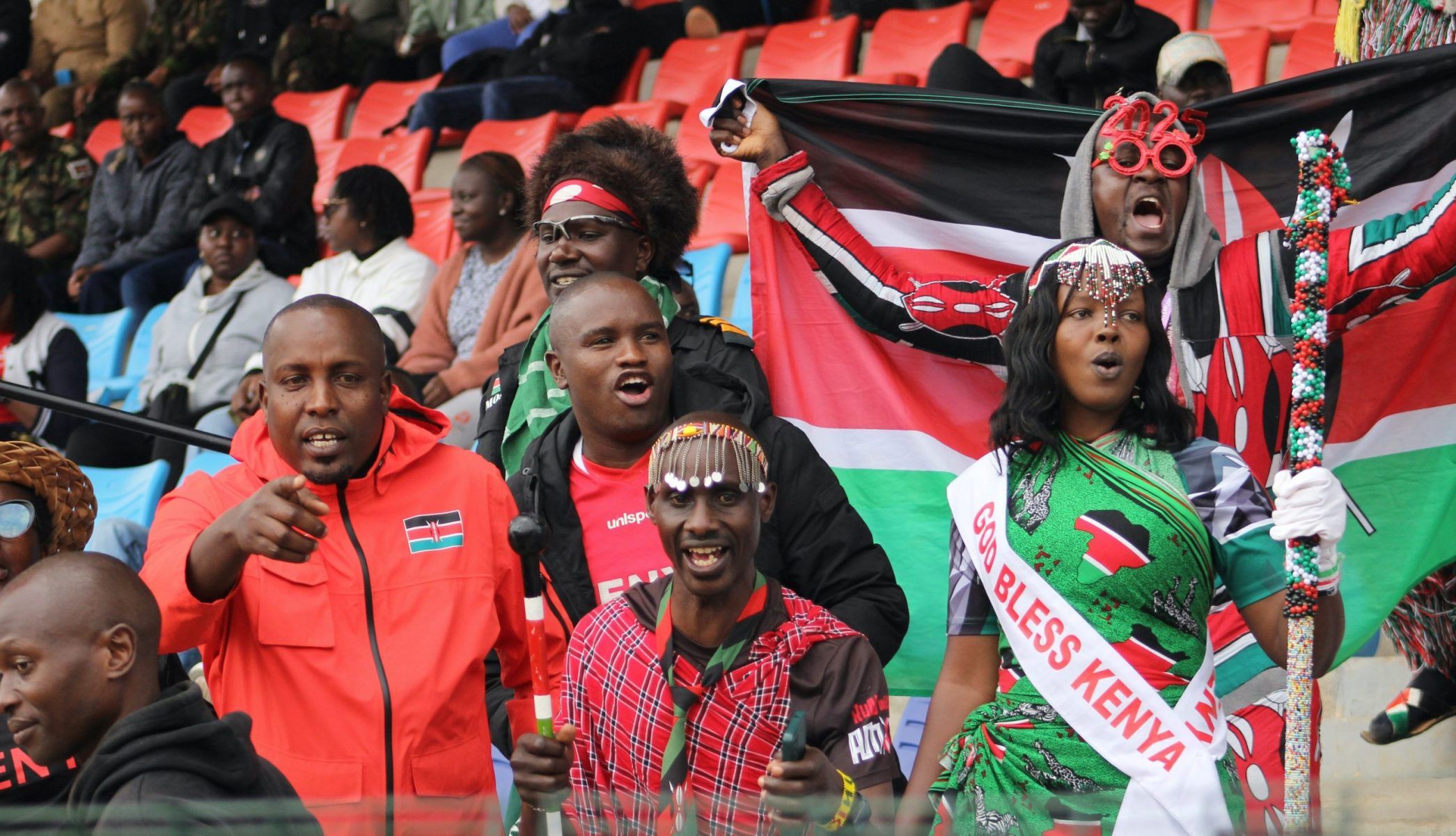 Supporter tenant des drapeaux du kenya dans un stade de foot