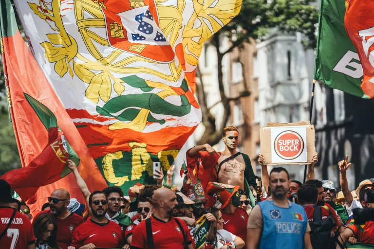 Foule de supporters portugais réunis avec drapeaux, maillots rouges et verts pour encourager leur équipe de football.