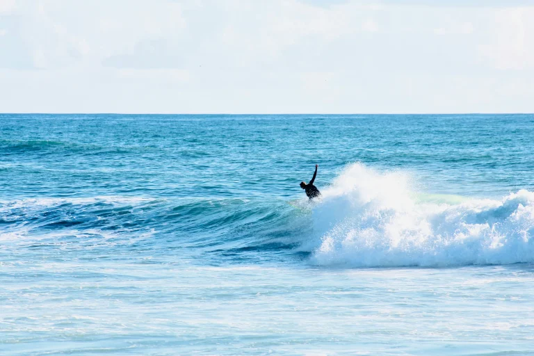 Surfeur affrontant une vague de l’océan Atlantique, illustrant les expériences de surf sur la côte portugaise.